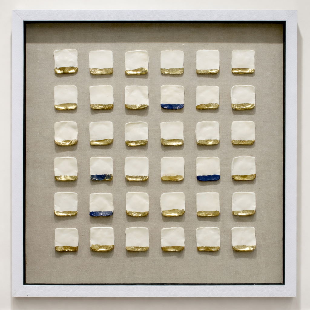 Framed artwork with square tiles featuring gold and blue accents on a beige background
